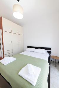 a bedroom with a bed with a green blanket at Annas Apartment Kalithea in Kallithea Halkidikis