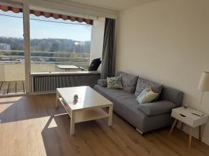ein Wohnzimmer mit Sofa und Tisch in der Unterkunft Ostsee Apartment mit Meerblick in Sierksdorf