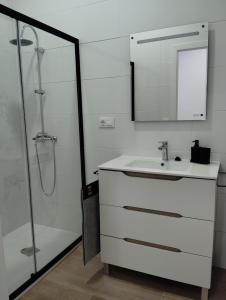 une salle de bain blanche avec un lavabo et une douche dans l'établissement Apartamento FERIA, à Fuentes de Andalucía