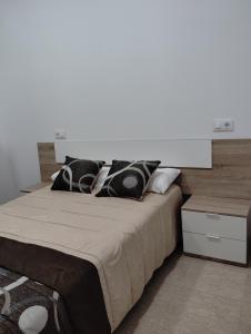 - un lit avec des oreillers en noir et blanc dans une chambre dans l'établissement Apartamento FERIA, à Fuentes de Andalucía