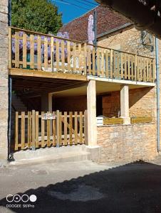 una terraza de madera en el lateral de una casa en Maison Les Glycines, en La Roque-Gageac