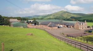 an aerial view of a farm with a grass field at Clyde Cottage in Lamington