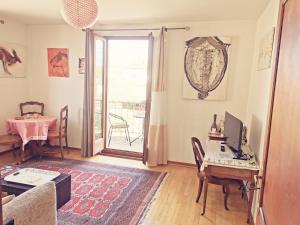 a living room with a table and a desk with a computer at Maison LES 3 ROSES in Wolfisheim +9 photos