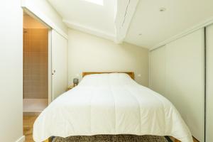 a bedroom with a white bed and a shower at Duplex Neuf Hyper Centre Idéal Curistes in Dax