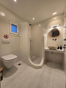 een witte badkamer met een toilet en een wastafel bij Magia's Residence in Naousa +26 foto's