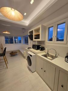 een keuken met een spoelbak en een wasmachine bij Magia's Residence in Naousa