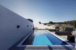 een zwembad in de achtertuin van een huis bij Magia's Residence in Naousa