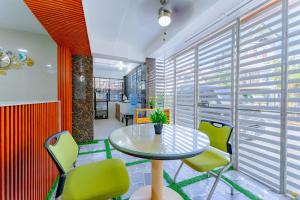 a table and chairs in a room with windows at Spacious Family Getaway for Big Groups in Lapu Lapu City +21 photos