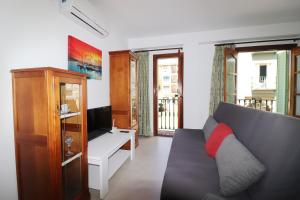 a living room with a couch and a desk and a television at Casa Miramar en el centro de Nerja in Nerja