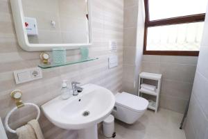 a white bathroom with a sink and a toilet at Casa Miramar en el centro de Nerja in Nerja +12 photos