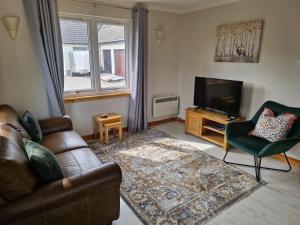 洛赫吉尔普黑德Kings Reach - Crinan Cottage的带沙发和电视的客厅