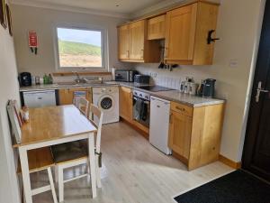洛赫吉尔普黑德Kings Reach - Crinan Cottage的配有木质橱柜、水槽和桌子的厨房