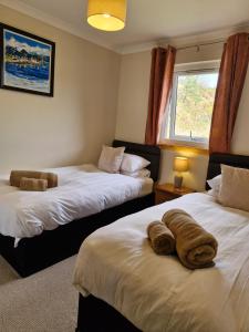 洛赫吉尔普黑德Kings Reach - Crinan Cottage的一间酒店房间，有两张床，床上有毛巾
