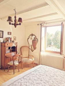 a bedroom with a bed and a desk and a chair at Maison LES 3 ROSES in Wolfisheim