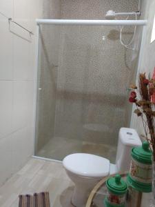 a bathroom with a toilet and a glass shower at Chalé Recanto na Montanha in Serra Negra +8 photos