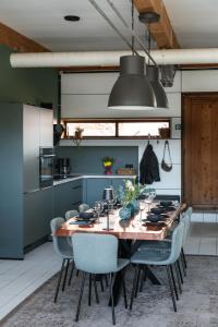 a kitchen with a wooden table and chairs at Die Badeanstalt I Loft Nürnberg I 5 Minuten zu Fuß zum kostenlosen Naturbad I Messenähe I Waldnähe in Postbauer-Heng