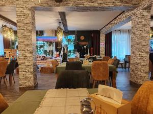 a restaurant with tables and chairs in a room at Hotel Popasul Regelui Transalpina in Tău Bistra