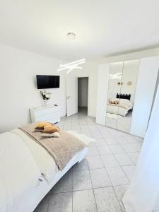 a white bedroom with a bed and a mirror at la casa di jo in Rome