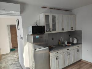 a kitchen with a stainless steel refrigerator and white cabinets at Apartamenty Wisła Lipowa 16-4B in Wisła