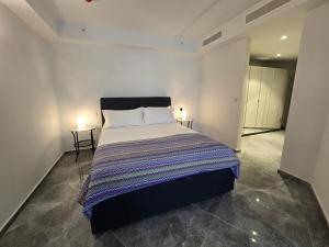a bedroom with a large bed with two lamps at Mercury Suites - Skydream Getaways in St. Julianʼs