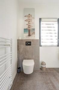 a bathroom with a white toilet and a window at Salles, Maison à 30 min d'Arcachon in Salles