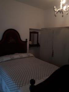 a bedroom with a bed and a chandelier at Il poggetto di Barbara Casa Grigia in Montorgiali