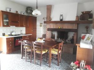 a kitchen with a table and chairs and a fireplace at Il poggetto di Barbara Casa Grigia in Montorgiali +4 photos