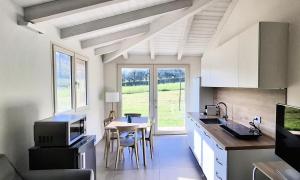 a kitchen with white cabinets and a table with chairs at Colle Gelso in Cesena