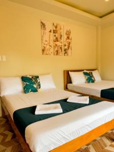 two beds in a room with yellow walls at VJB Homestay in El Nido