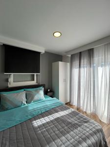 a bedroom with a large bed and a large window at Apartmani Naša priča in Višegrad