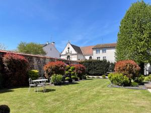 un giardino con panchina nel cortile di una casa di Le Jardin d'Hiver a Chalons en Champagne