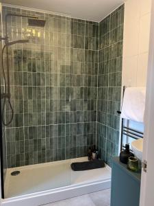 a green tiled bathroom with a shower and a tub at Church Mouse Cottage Clitheroe in Clitheroe +8 photos