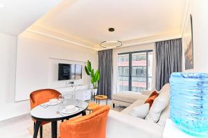 a living room with a white couch and a table at Riara One Residency, Kilimani in Nairobi