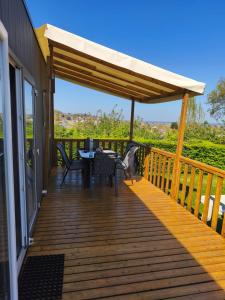 a wooden deck with a table and chairs on it at Mobil home Premium in Houlgate
