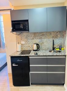 a kitchen with a sink and a microwave at Hermoso Studio a metros del Obelisco in Buenos Aires