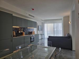 a kitchen with a glass table in a living room at Mercury Suites - Skydream Getaways in St. Julianʼs