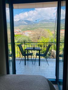 a bedroom with a table and chairs on a balcony at Selini Apartments Mani in Agios Nikolaos