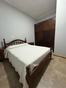 a bedroom with a large bed and a wooden cabinet at Departamento en Catamarca capital in San Fernando del Valle de Catamarca