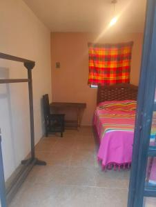 une chambre avec un lit et un bureau dans une pièce dans l'établissement Hostel del bosque, à San Cristóbal de Las Casas