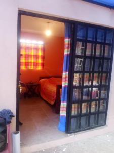 une porte ouverte sur une chambre avec un lit dans une pièce dans l'établissement Hostel del bosque, à San Cristóbal de Las Casas