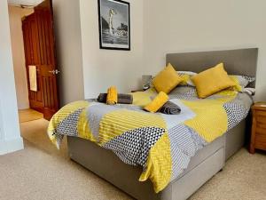 a bedroom with a bed with yellow and black pillows at Stunning spacious Apartment on River Ness in Inverness