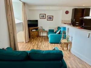 a living room with a blue couch and a television at Stunning spacious Apartment on River Ness in Inverness