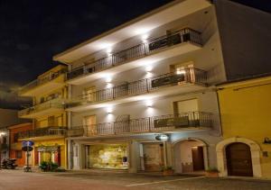 a building with two balconies on a street at night at Appartamenti Lira in Cattolica
