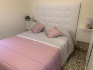 a bedroom with a bed with pink pillows on it at Apartamento en Xinzo de Limia in Xinzo de Limia