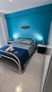 una camera da letto con un letto con una parete blu di STELLA MARINA Apartment a Mascali