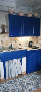 a blue kitchen with a sink and blue cabinets at Kynosoura's sea view in Ambelákia