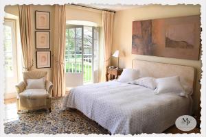 Brinon-sur-SauldreにあるDomaine d'exception 12 chambresのベッドと椅子と窓のある寝室