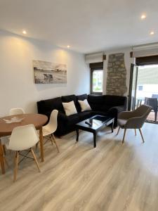 a living room with a black couch and a table at Apartamento Pueblo De Mogro in Mogro