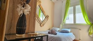 a bedroom with a bed and a vase with a flower at Center Lux Apartment Marijana in Novi Sad