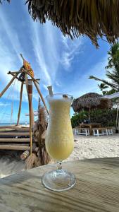 a drink in a glass sitting on a table on the beach at Bavaro Punta Cana Beach pool ducassi sol caribe Los corales in Punta Cana